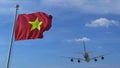 Commercial airplane landing behind waving Vietnamese flag. Travel to Vietnam conceptual 3D rendering