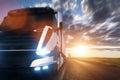 Commercial cargo delivery truck with trailer driving on highway at sunset. Royalty Free Stock Photo