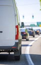 Commercial cargo mini van driving on the city road with traffic light and signs Royalty Free Stock Photo