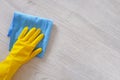 Commercial cleaning company concept. Hand in rubber protective glove with blue microfiber cloth is wiping floor. Copy space Royalty Free Stock Photo