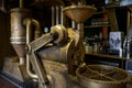 A commercial, copper coffeebean grinder is displayed in a coffeehouse, to entice and interest customers while waiting for a cup of