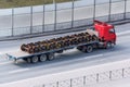 Commercial delivery cargo truck with open trailer driving on the highway, loaded with wheelsets from a train of wagons rail train Royalty Free Stock Photo