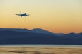 Commercial jet airplane landing at sunset Royalty Free Stock Photo