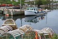 Wooden lobster traps and a fishing boat in Peggy`s Cove, Nova Scotia Royalty Free Stock Photo