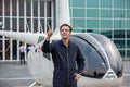 Commercial man pilot in technician suit standing in front of helicopter after check and maintenance engine Royalty Free Stock Photo