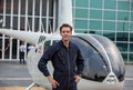 Commercial man pilot in technician suit standing in front of helicopter after check and maintenance engine Royalty Free Stock Photo