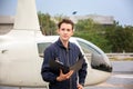 Commercial man pilot in technician suit standing in front of helicopter after check and maintenance engine Royalty Free Stock Photo