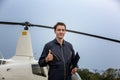 Commercial man pilot in technician suit standing in front of helicopter after check and maintenance engine Royalty Free Stock Photo