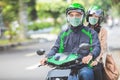 Commercial motorcycle taxi driver taking his passenger to her de Royalty Free Stock Photo