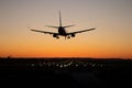 Commercial passenger airplane is landing on the airport runway during sunset Royalty Free Stock Photo