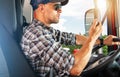 Commercial Trucker Driver Behind the Truck Wheel Talking Over Radio Royalty Free Stock Photo