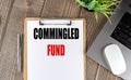 COMMINGLED FUND text on clipboard paper with laptop, mouse and pen Royalty Free Stock Photo