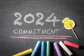 2024 Commitment Concept. Colored pieces of chalk on a dark chalkboard