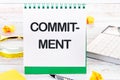 COMMITMENT Word Written on a blank sheet of a desktop notebook Royalty Free Stock Photo