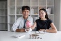 A committed Asian couple saves money together. Counting the coins in the piggy bank