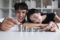 A committed Asian couple saves money together. Counting the coins in the piggy bank