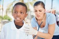 Committed to improving health in the developing world. a volunteer nurse examining a young patient with a stethoscope at