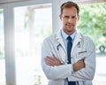 Committed to providing everyday healthcare. Portrait of a male doctor standing with his arms crossed in a hospital. Royalty Free Stock Photo