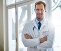 Committed to providing everyday healthcare. Portrait of a smiling male doctor standing with his arms crossed in a Royalty Free Stock Photo