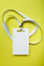 A common blank label name tag hanging on the neck with a red thread. Empty layout isolated on yellow