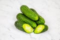 Common cucumber Latin Cucumis sativus is green in a pile cut on a marble white table. Vegetables, fruits Royalty Free Stock Photo