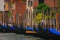 Crowded traditional wooden poles with mooring Venetian Gondolas at Venice, Italy