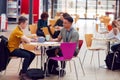 Communal Area Of Busy College Campus With Students Working At Tables