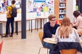 Communal Area Of Busy College Campus With Students Working At Tables