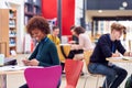 Communal Area Of Busy College Campus With Students Working At Tables