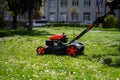 Communal services gardener worker man using lawn mower for grass cutting in city park Royalty Free Stock Photo