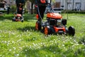 Communal services gardener worker man using lawn mower for grass cutting in city park Royalty Free Stock Photo