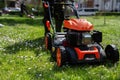 Communal services gardener worker man using lawn mower for grass cutting in city park Royalty Free Stock Photo