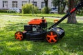 Communal services gardener worker man using lawn mower for grass cutting in city park Royalty Free Stock Photo