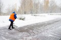 Communal services workers in uniform cleaning city street with a shovels. Snow removal in winter park. Royalty Free Stock Photo