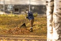 A communal worker cleans fallen leaves in autumn in the park