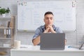 Communicate with students online remotely and video call with teacher. Concentrated man looking at laptop and listening Royalty Free Stock Photo