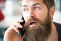 Communication concept. Man with beard and mustache mobile phone conversation defocused background. Bearded man hold Royalty Free Stock Photo