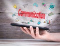 Communication concept. Tablet computer in the hand. Old wooden background Royalty Free Stock Photo