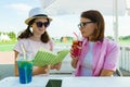 Communication of parent and teenager. Mother and daughter teenager talking sitting in summer street cafe. Royalty Free Stock Photo