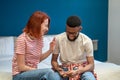 Young happy diverse couple laughing while sitting on bed and talking. Communication in relationships Royalty Free Stock Photo