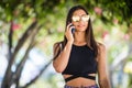 Communication, technology, leisure and people concept - happy young latin woman or teenage girl calling on smartphone at city stre Royalty Free Stock Photo