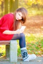 Sad woman in park with phone Royalty Free Stock Photo