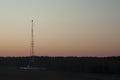 Communication tower on the background of sunset and clear sky. Royalty Free Stock Photo