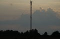 Communication tower on the background of twilight in the field Royalty Free Stock Photo