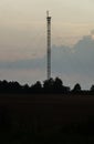 Communication tower on the background of twilight in the field Royalty Free Stock Photo