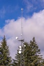 Cellular communication tower with group of parabolic antennas against clouds on a blue sky Royalty Free Stock Photo