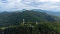 Communication tower, radio tower, telecommunication tower or transmission tower in the forest on the mountain with clouds and blue Royalty Free Stock Photo