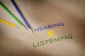 Colorful hearing not equal listening written on brown paper background with color pencil Royalty Free Stock Photo