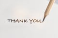 Thank you written on white paper with pencil Royalty Free Stock Photo