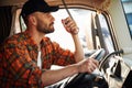 Communication by using radio. Young truck driver in casual clothes Royalty Free Stock Photo